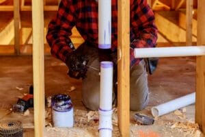 man working on wood and pipe
