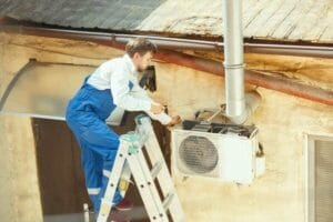 HVAC technician repairing AC unit – air conditioning & heating services.
